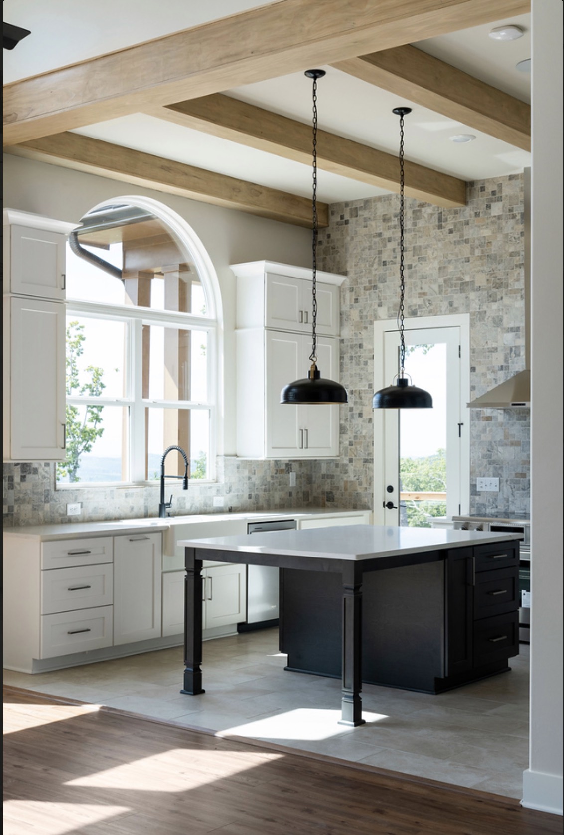 Kitchen with wood beam ceiling and stone backsplash in a Rezide custom home